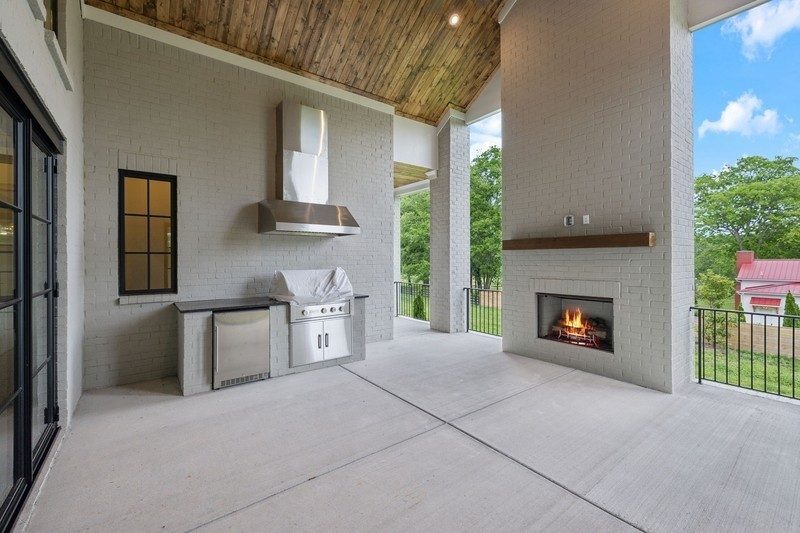 Representative photo: covered outdoor living area with a fireplace in an Elmsley plan home, not 1817 Dartmouth Drive, Brentwood TN