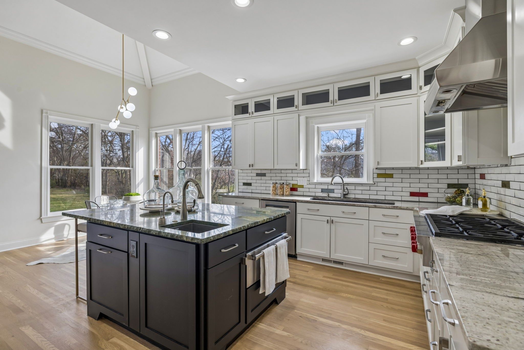 Kitchen with a dark island, white cabinets, and stainless appliances at 9004 Old Smyrna Road, Brentwood TN
