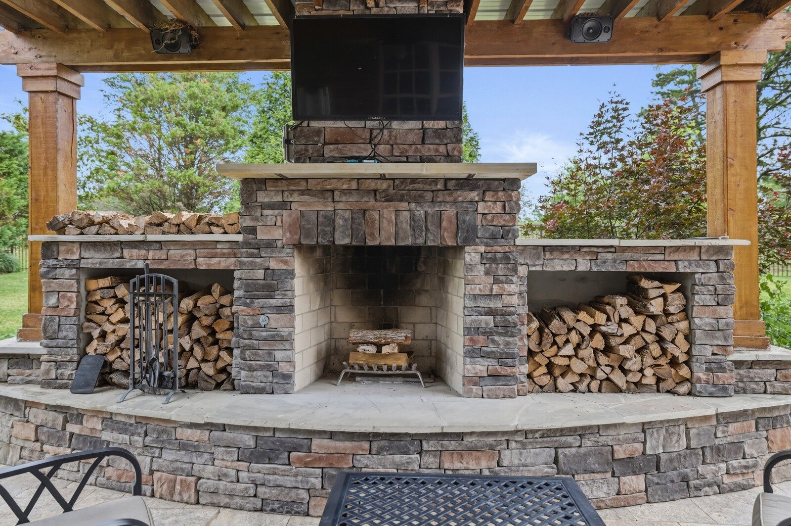 Covered outdoor living area with a stone fireplace at 9405 Big Horn Ridge, Brentwood TN