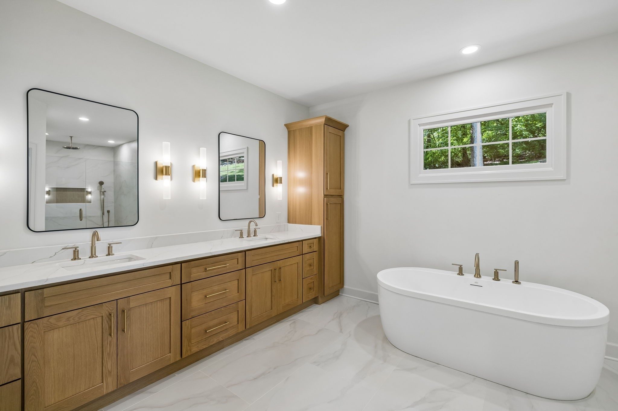 Primary bath with a freestanding tub and wood vanities at 9442 Foothills Drive, Brentwood TN